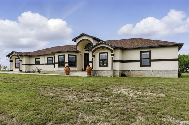 1110 Atascosa County Road 101, Floresville, TX 78114 - view of front of home with a front lawn, stucco siding, and roof with shingles