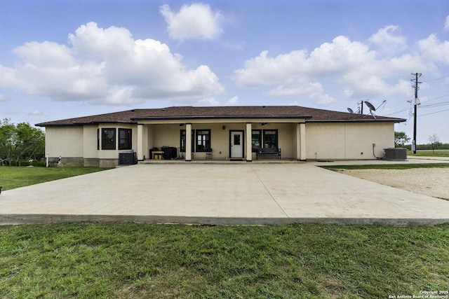 1110 Atascosa County Road 101, Floresville, TX 78114 - back of property featuring central AC unit, a yard, ceiling fan, and stucco siding
