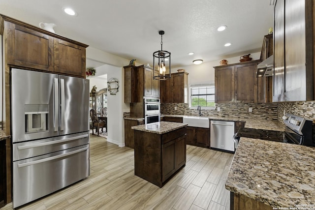 1110 Atascosa County Road 101, Floresville, TX 78114 - kitchen with stainless steel appliances, a sink, decorative backsplash, recessed lighting, and dark brown cabinetry