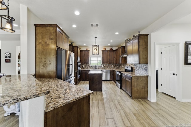 1110 Atascosa County Road 101, Floresville, TX 78114 - kitchen with appliances with stainless steel finishes, recessed lighting, decorative backsplash, light stone countertops, and light wood-type flooring