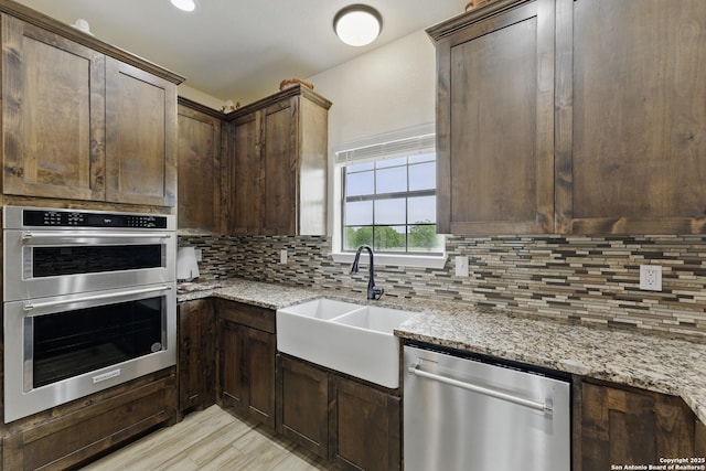 1110 Atascosa County Road 101, Floresville, TX 78114 - kitchen featuring stainless steel appliances, a sink, backsplash, and light stone countertops