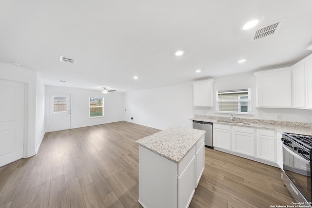 12056 Luckey Villa, San Antonio, TX 78252 - kitchen featuring dishwasher, black range with gas stovetop, a sink, a center island, and plenty of natural light