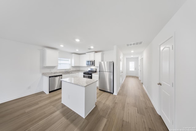 12056 Luckey Villa, San Antonio, TX 78252 - kitchen with appliances with stainless steel finishes, a sink, white cabinetry, recessed lighting, and light wood-style floors