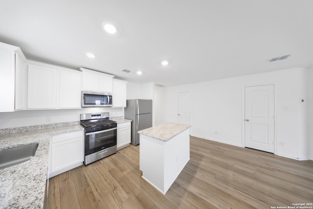12056 Luckey Villa, San Antonio, TX 78252 - kitchen featuring stainless steel appliances, a kitchen island, light wood-type flooring, white cabinetry, and recessed lighting