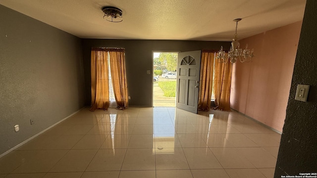 1906 Perlita, San Antonio, TX 78224 - tiled spare room featuring a chandelier, baseboards, a textured wall, and a textured ceiling