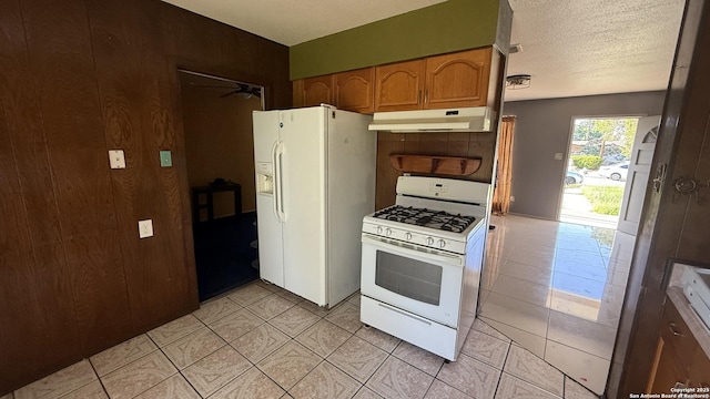 1906 Perlita, San Antonio, TX 78224 - kitchen featuring white appliances, under cabinet range hood, a ceiling fan, light tile patterned floors, and brown cabinetry