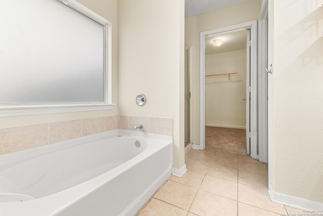 6739 Nora Vista Way, San Antonio, TX 78233 - full bathroom with tile patterned floors, a spacious closet, a bath, baseboards, and a stall shower