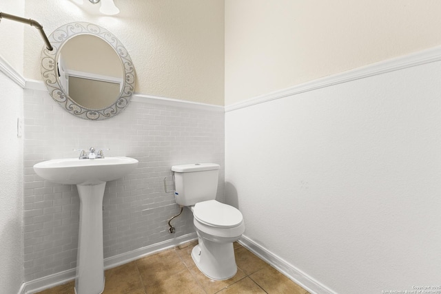 6739 Nora Vista Way, San Antonio, TX 78233 - bathroom featuring tile patterned flooring, toilet, a sink, and wainscoting