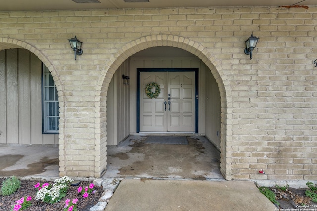 view of exterior entry featuring brick siding
