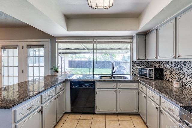 kitchen featuring black dishwasher, a sink, stainless steel microwave, light tile patterned floors, and tasteful backsplash