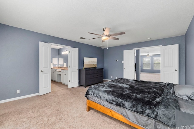 10607 Carmona, Helotes, TX 78023 - bedroom featuring light colored carpet, baseboards, ensuite bath, and ceiling fan