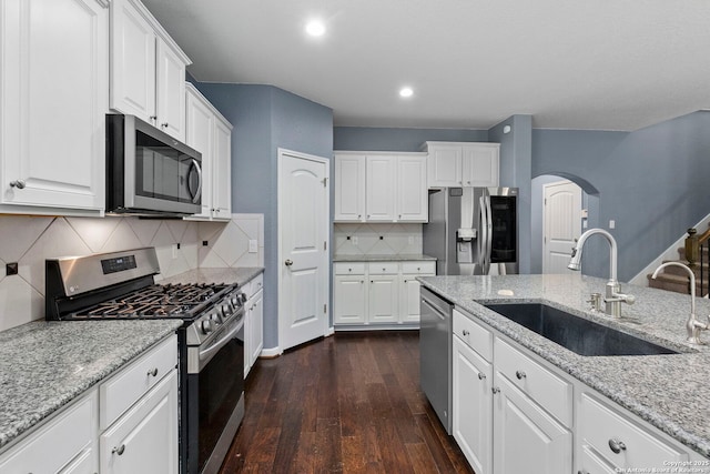 10607 Carmona, Helotes, TX 78023 - kitchen with appliances with stainless steel finishes, a sink, arched walkways, dark wood-style flooring, and white cabinets