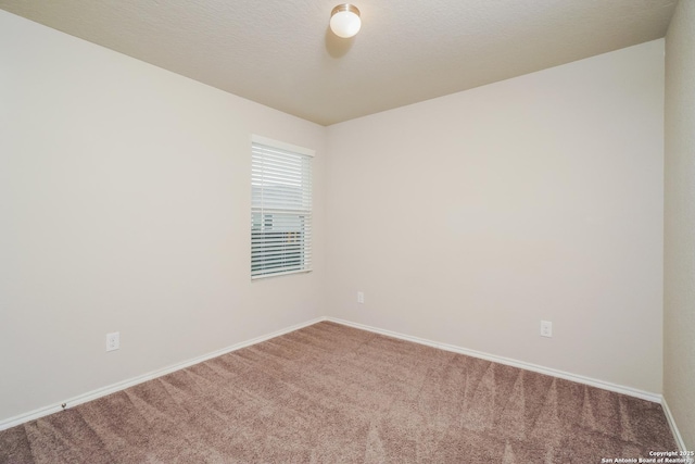 carpeted empty room featuring baseboards