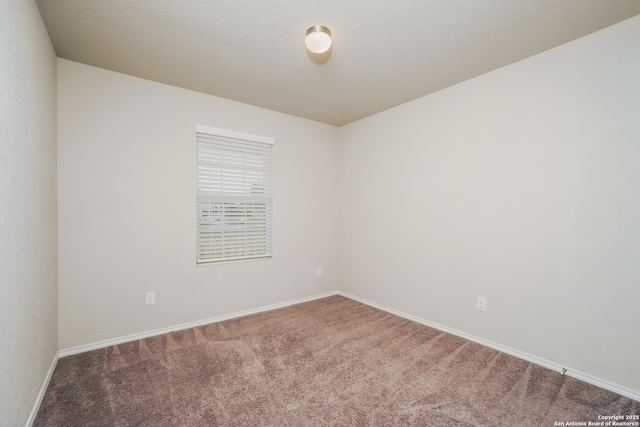 unfurnished room featuring carpet and baseboards