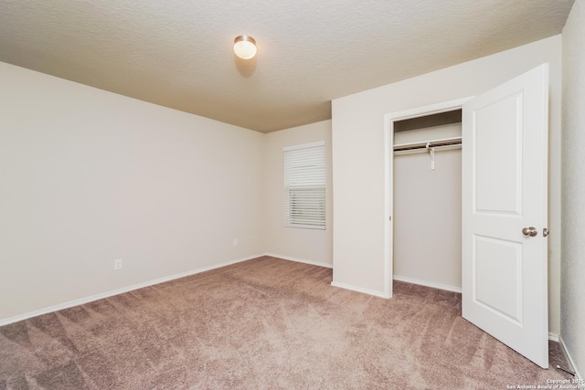 unfurnished bedroom with light carpet, baseboards, and a closet