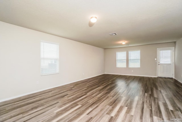 spare room featuring dark wood finished floors and baseboards