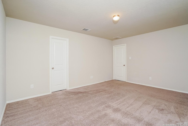 unfurnished room featuring light colored carpet and baseboards