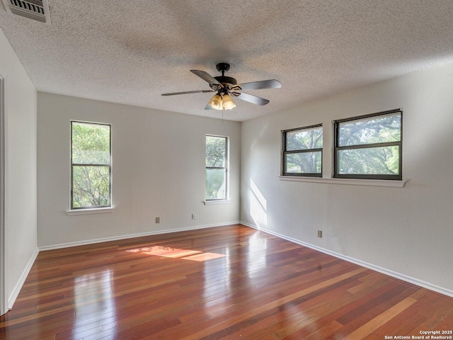 12802 Country Crst, San Antonio, TX 78216 - spare room with wood-type flooring, a textured ceiling, healthy amount of natural light, a ceiling fan, and baseboards