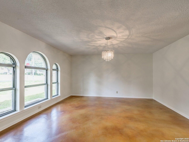 12802 Country Crst, San Antonio, TX 78216 - spare room featuring finished concrete flooring, a chandelier, a textured ceiling, and baseboards