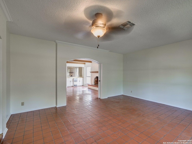 12802 Country Crst, San Antonio, TX 78216 - empty room featuring arched walkways, a ceiling fan, a textured ceiling, baseboards, and tile patterned flooring