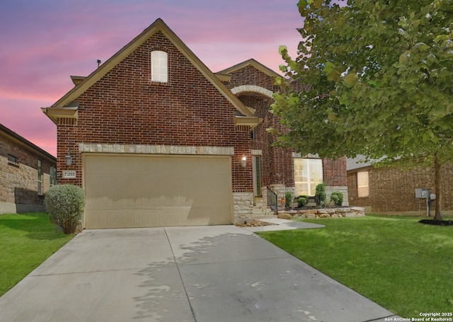 traditional-style house featuring brick siding, driveway, a front yard, and a garage