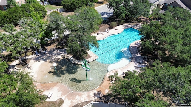 aerial view of a pool and a tree filled landscape