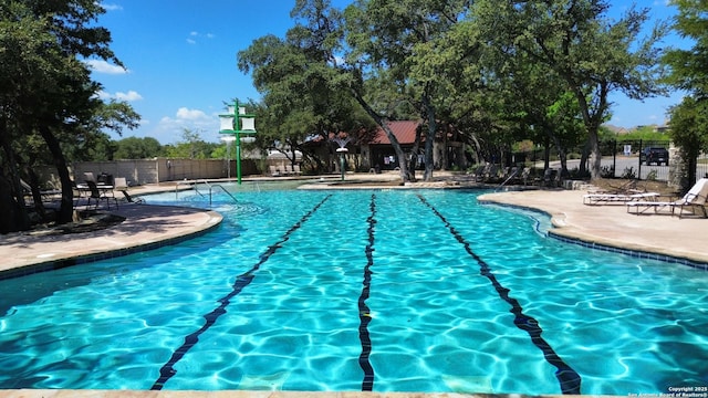 community pool featuring fence and a patio