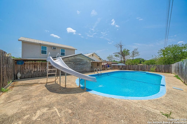 1004 Leona, Cotulla, TX 78014 - view of pool with a water slide, a fenced backyard, and a patio area