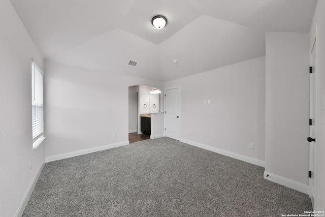 6514 Comanche Post, San Antonio, TX 78233 - unfurnished bedroom featuring dark carpet, lofted ceiling, arched walkways, and baseboards