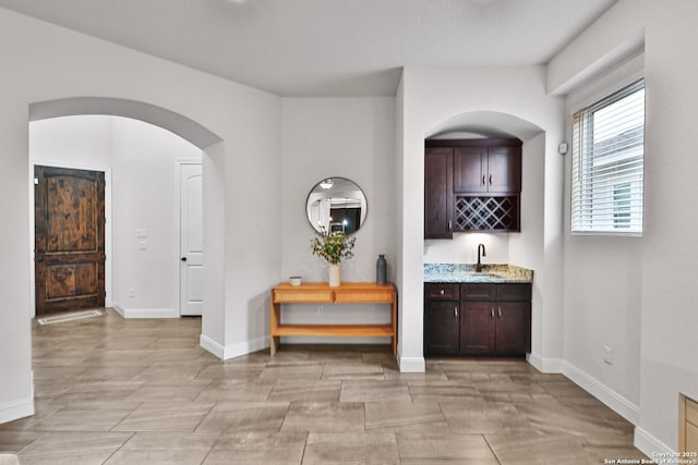 6514 Comanche Post, San Antonio, TX 78233 - hallway featuring a sink, baseboards, and arched walkways