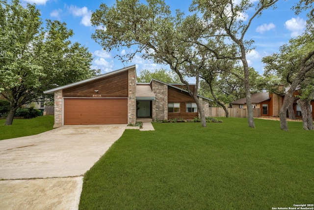 mid-century modern home featuring concrete driveway and an attached garage