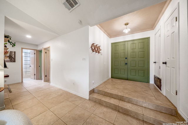 foyer entrance featuring light tile patterned floors, lofted ceiling, and baseboards