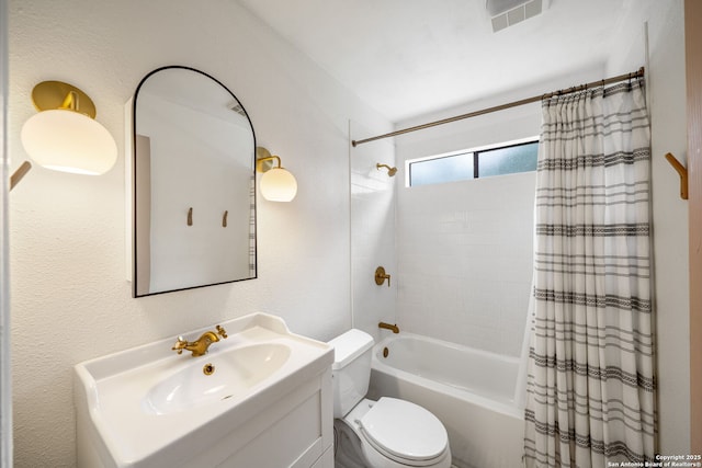 bathroom featuring shower / bath combo, toilet, vanity, and a textured wall