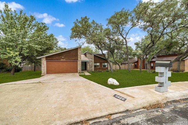 mid-century home with a garage, driveway, and brick siding