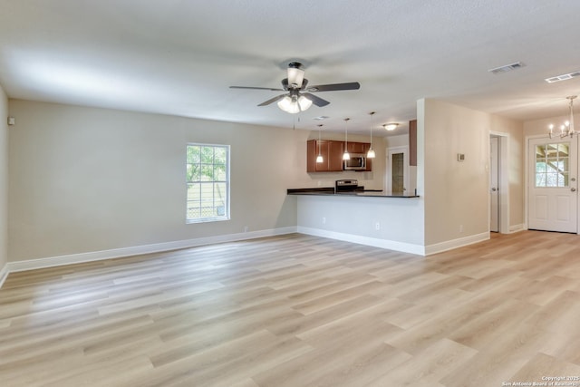 9015 Spanish Cv, San Antonio, TX 78242 - unfurnished living room featuring a chandelier, baseboards, ceiling fan, and light wood-style floors