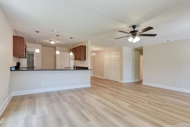 9015 Spanish Cv, San Antonio, TX 78242 - unfurnished living room featuring a ceiling fan, light wood-style flooring, a chandelier, a sink, and baseboards