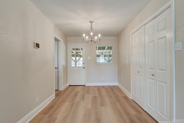 9015 Spanish Cv, San Antonio, TX 78242 - unfurnished dining area with a chandelier, light wood-style floors, and baseboards