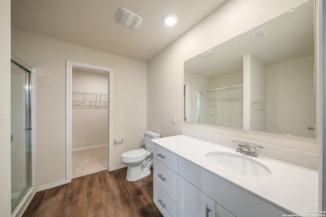 13758 Prospector Post, San Antonio, TX 78253 - bathroom with a shower stall, wood finished floors, toilet, vanity, and a walk in closet
