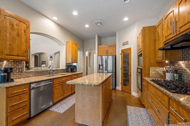 125 Stone Cyn, Fredericksburg, TX 78624 - kitchen with black appliances, a sink, a kitchen island, under cabinet range hood, and arched walkways