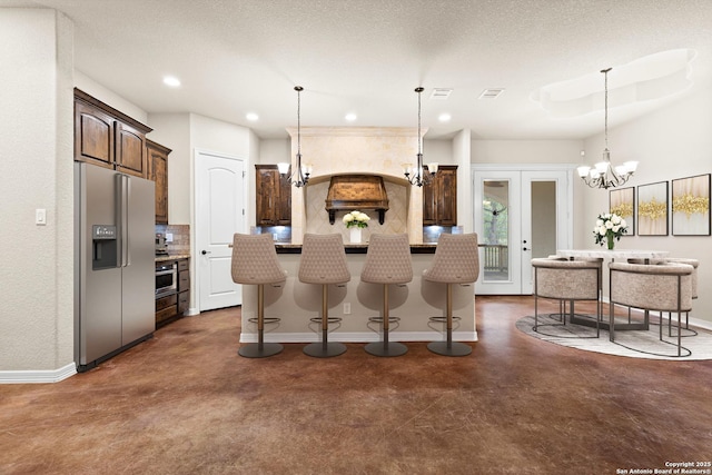 105 Saddle Up, La Vernia, TX 78121 - kitchen with stainless steel fridge with ice dispenser, a chandelier, tasteful backsplash, baseboards, and recessed lighting