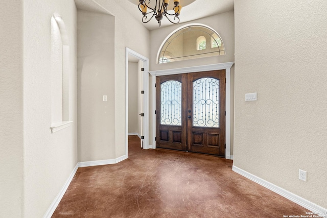 105 Saddle Up, La Vernia, TX 78121 - entrance foyer with finished concrete flooring, a chandelier, a textured wall, baseboards, and french doors