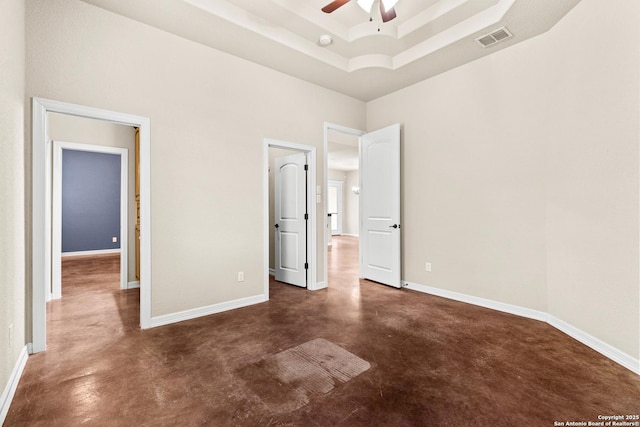105 Saddle Up, La Vernia, TX 78121 - unfurnished bedroom featuring concrete floors, baseboards, a raised ceiling, and a towering ceiling