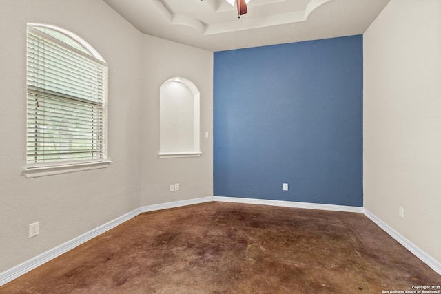 105 Saddle Up, La Vernia, TX 78121 - empty room with concrete floors, a ceiling fan, and a tray ceiling