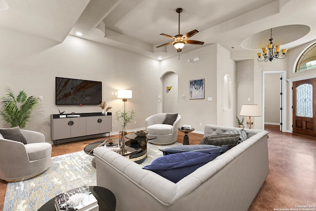 105 Saddle Up, La Vernia, TX 78121 - living area featuring a tray ceiling, arched walkways, a chandelier, a ceiling fan, and baseboards