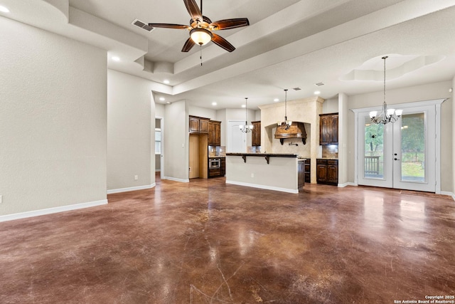 105 Saddle Up, La Vernia, TX 78121 - unfurnished living room with a chandelier, a raised ceiling, concrete flooring, recessed lighting, and a ceiling fan