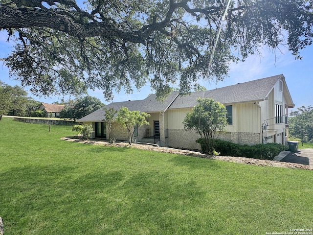 view of property exterior featuring a yard, a garage, brick siding, and a shingled roof