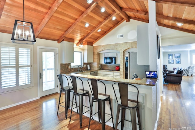 kitchen featuring stainless steel appliances, wooden ceiling, light wood-style flooring, a peninsula, and decorative backsplash