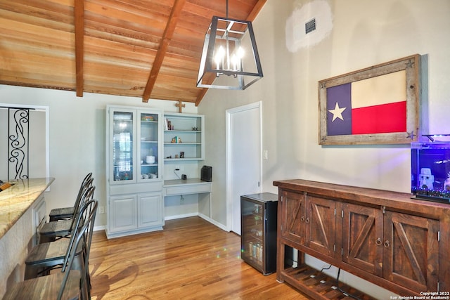 office area featuring wood ceiling, light wood-style flooring, beverage cooler, built in study area, and baseboards