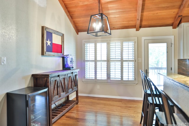 dining space with wood ceiling, plenty of natural light, light wood-style floors, baseboards, and beverage cooler