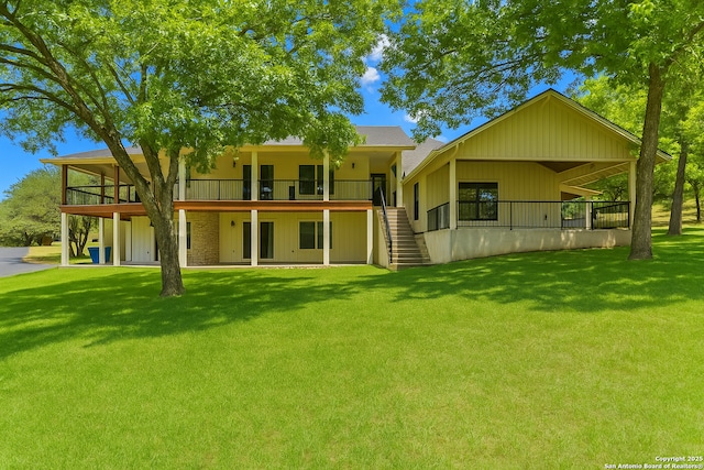 back of property featuring stairway, a yard, and a deck